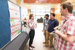 Participants in the q-bio Summer School at Colorado State University discuss their research and socialize at a poster session and reception, June 5, 2017.